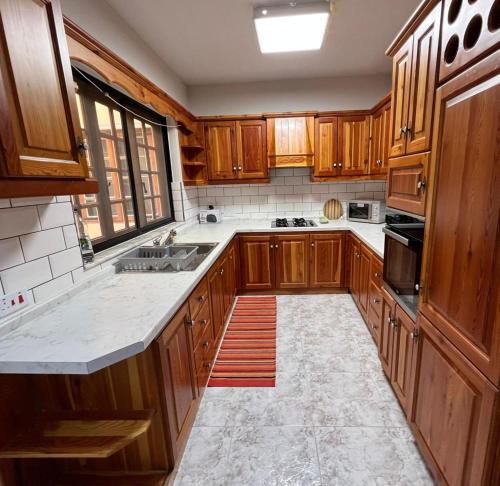 a large kitchen with wooden cabinets and a sink at Marsaskala Sea Side Retreat in Marsaskala