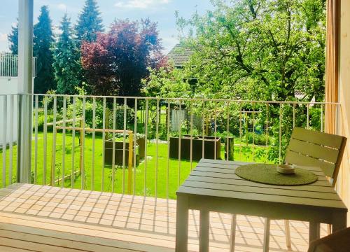赫爾布蘭茲的住宿－Haus Olga，阳台配有桌子,享有庭院的景色