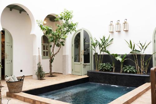 a courtyard with a swimming pool in a house at Riad Al Uzza in Marrakesh