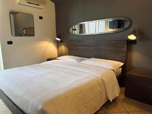 a bedroom with a large bed and a mirror at Hotel Ristorante San Giuseppe in Cernobbio