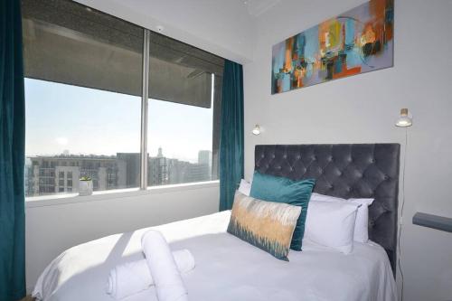 a bedroom with a bed with a large window at Power 24/7 Wifi Views of Harbour V&A Pool CTICC in Cape Town