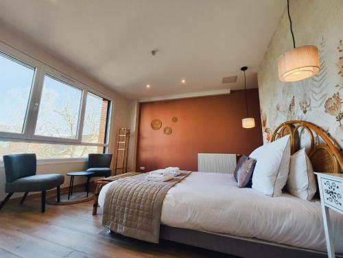 a bedroom with a large bed in a room with windows at FORMOSA DIJON in Étaules