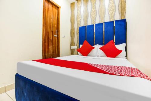 a bedroom with a bed with red pillows at OYO Flagship 80943B Hotel Blue Shine in Ludhiana