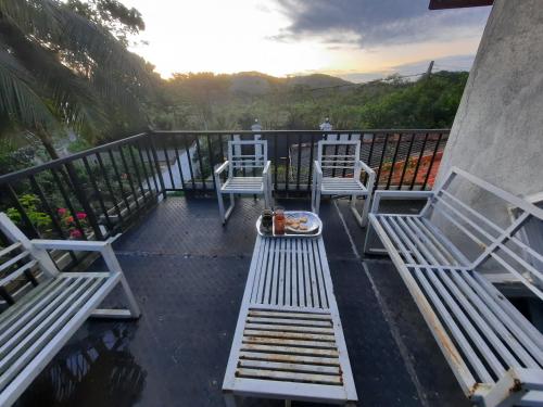 - un balcon avec deux chaises blanches et une table dans l'établissement Mellows Home, à Horana