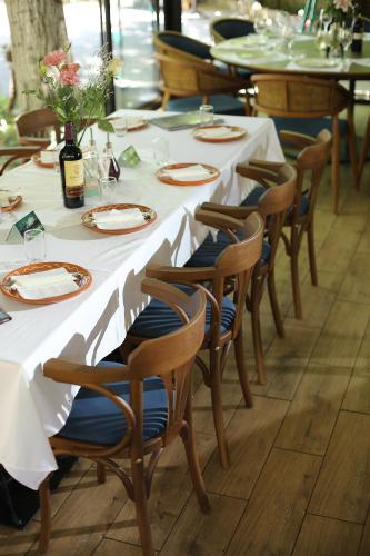 a table with white tables and chairs with plates and flowers at AV Smart Apartment in Pančevo
