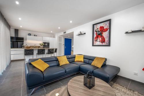 un salon avec un canapé bleu et une cuisine dans l'établissement C035-Cannes Centre appartement 3 pièces avec parking, à Cannes