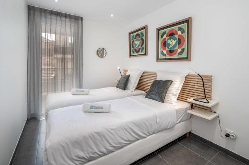 une chambre avec deux lits et une fenêtre dans l'établissement C035-Cannes Centre appartement 3 pièces avec parking, à Cannes