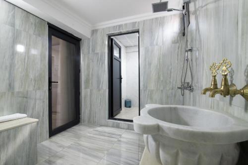 a bathroom with a large tub and a mirror at EÖB TAKSİM HOTEL in Trabzon