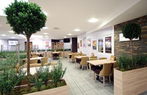 restauracja ze stołami, krzesłami i drzewem w obiekcie Poppy 44 w mieście Ferndown