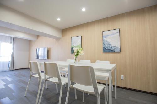 a dining room with a white table and chairs at 1min walk to Higashi Shinjuku sta 8PPL Shinjuku Gyoen丶 National Garden丶 Kabukicho丶 Shinjuku Station丶 Golden Gai丶 Tokyo Metropolitan Government Building YYoQA in Tokyo