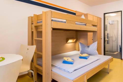 a bunk bed in a room with a table and a chair at Jugendherberge Ratzeburg am See in Ratzeburg