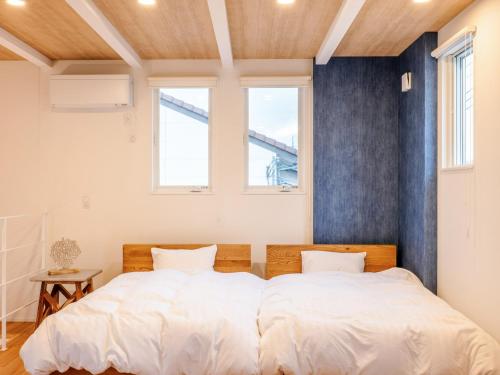 ein Schlafzimmer mit einem großen Bett und zwei Fenstern in der Unterkunft AMAZING LIFESTYLE GLAMPING HOTEL - Vacation STAY 44057v in Nagahama
