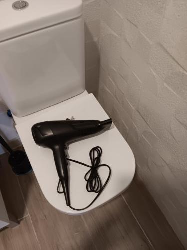 - un siège noir sur des toilettes blanches dans la salle de bains dans l'établissement Plaza de Castilla2 Apartments2, à Madrid