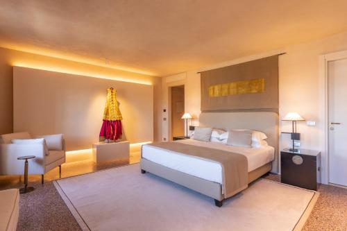 Hotel Palazzo Durazzo Suites في جينوا: غرفة نوم كبيرة بها سرير وكرسي