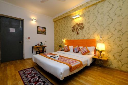 a bedroom with a large bed with a wooden headboard at Lime Tree Premier near Medanta Medicity in Gurgaon
