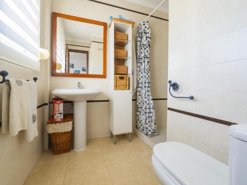 een badkamer met een wastafel, een toilet en een spiegel bij Cubo's Chaparral Townhouse & Community Pool in Mijas Costa