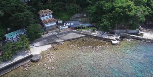 an aerial view of a house next to the water at Dive and Trek Resort and Marine Sanctuary in Bauan