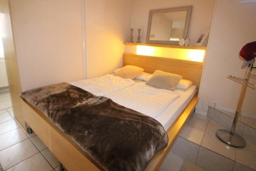 een klein bed in een kamer met een spiegel bij Ferienwohnung 110 in Niendorf an der Ostsee in Niendorf