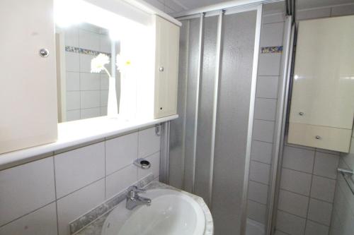 een badkamer met een wastafel, een spiegel en een toilet bij Ferienwohnung 110 in Niendorf an der Ostsee in Niendorf
