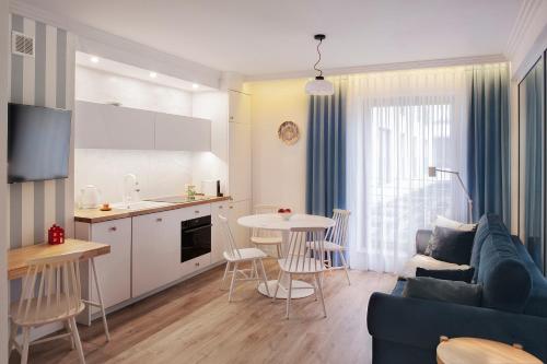 uma sala de estar com um sofá, uma mesa e uma cozinha em I Love Gdynia Apartments - apartament z parkingiem em Gdynia