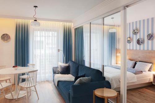 uma sala de estar com um sofá azul e uma cama em I Love Gdynia Apartments - apartament z parkingiem em Gdynia