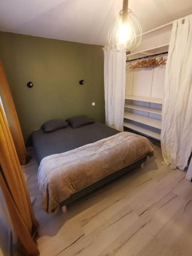 um quarto com uma cama no canto de um quarto em Maison entre ville et campagne em La Salvetat