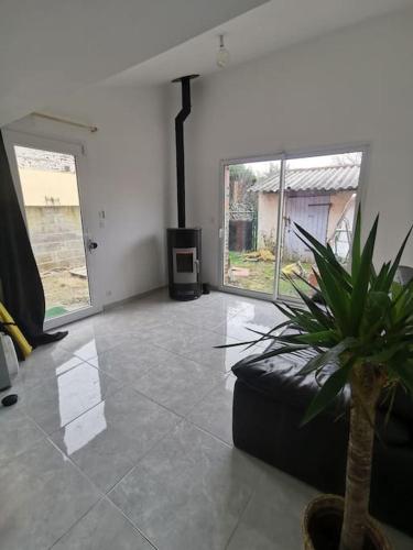 un salon avec une plante en pot et une grande fenêtre dans l'établissement Maison entre ville et campagne, à La Salvetat