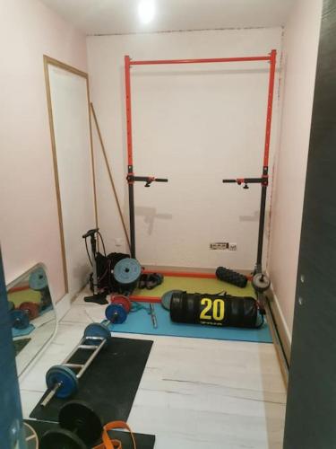 une salle de sport avec porte et poids dans l'établissement Maison entre ville et campagne, à La Salvetat