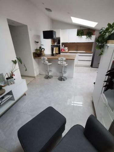 um quarto com uma cozinha com um balcão e bancos em Maison entre ville et campagne em La Salvetat