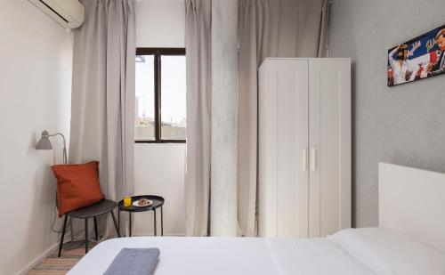 1 dormitorio con 1 cama, 1 silla y 1 ventana en Ran's Cozy Hotel Style apt en Tel Aviv