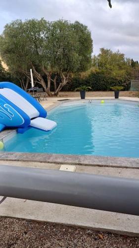 une piscine bleue avec un toboggan au milieu dans l'établissement Le 7, à Servian