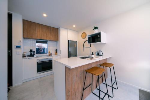 a kitchen with a counter and stools in it at Charming Retreat in the Heart of Christchurch City-CBD 