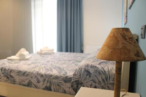 a lamp sitting on a table next to a bed at B&B Celeste - Palazzo D'Addario in Celenza Valfortore
