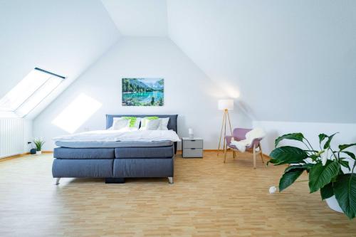 een slaapkamer met een bed en een stoel en een plant bij Kim Fewo 2 in Emmendingen