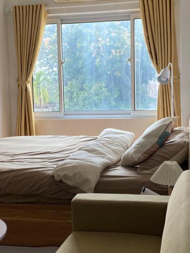 1 cama en un dormitorio con ventana grande en Lya Home, en Hanói