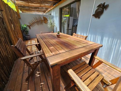 a wooden table and chairs on a porch at Leopard Corner Lodge in St Lucia