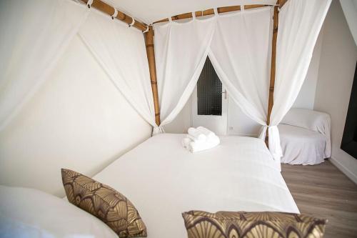 1 Schlafzimmer mit 2 Betten mit weißer Bettwäsche und Vorhängen in der Unterkunft Relax studio in Le Mée-sur-Seine