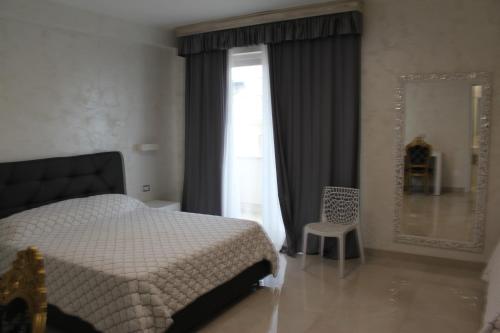 a bedroom with a bed and a window and a mirror at Hotel Presidente in Porto Cesareo