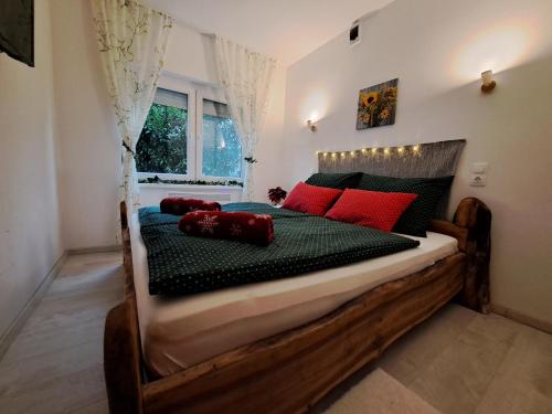 1 dormitorio con cama de madera y almohadas rojas. en Borbála Vendégház Igal, en Igal