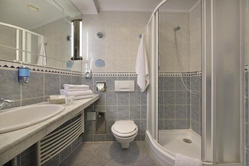 a bathroom with a toilet and a sink and a shower at Hotel Esprit in Prague