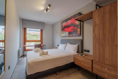 a bedroom with a large white bed and a window at Spirit Apartamentos Atxuri in Bilbao