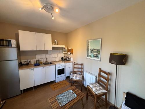 une cuisine avec des armoires blanches et une table et des chaises dans l'établissement Studio 28 m2 minimum 3 nuits, à Marseille