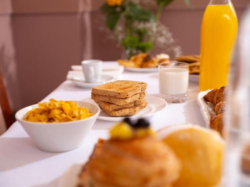 a table topped with plates of breakfast foods and orange juice at Hotel SAN PIO in San Giovanni Rotondo