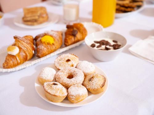 a table topped with plates of donuts and other pastries at Hotel SAN PIO in San Giovanni Rotondo