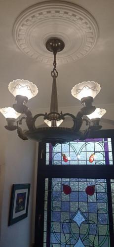 a chandelier hanging from a ceiling with a stained glass window at Jugendstilvilla voll renoviert in Falkenstein
