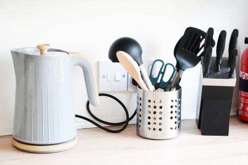 a cup of cooking utensils on a counter at Sherlock House - Stylish Home Sleeping up to 6 in Wallasey