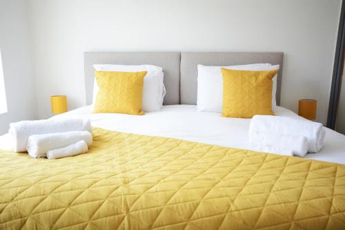 a bedroom with a large bed with yellow pillows at Sherlock House - Stylish Home Sleeping up to 6 in Wallasey