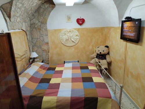 a bedroom with a teddy bear sitting next to a bed at Casa del Centro PT in Santa Caterina Villarmosa