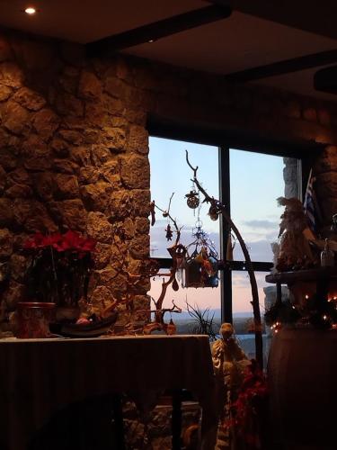 a room with a stone wall and a table and a window at Αέσκω in Vytina