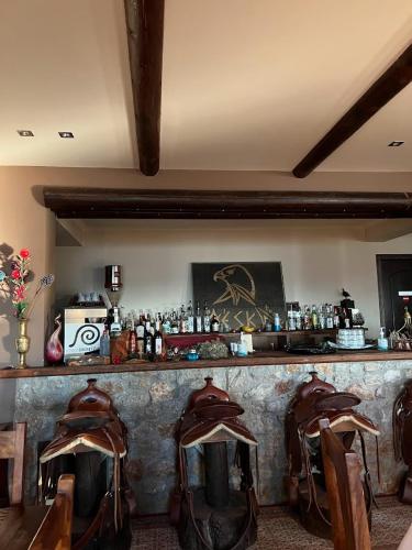 a bar with chairs and a counter with bottles at Αέσκω in Vytina
